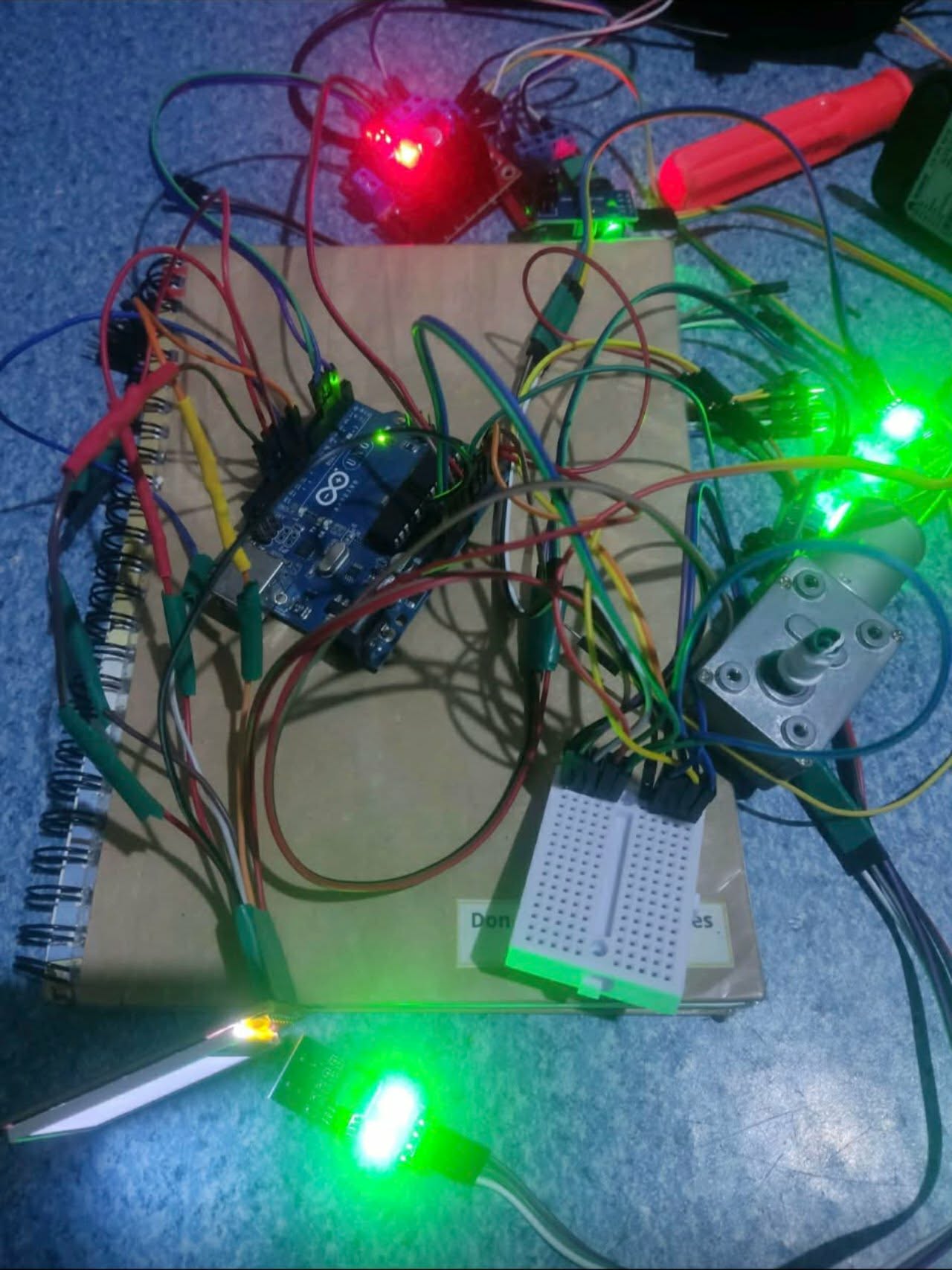 Coin sorter prototype electronics with a controller board, DC motor, wiring, and illuminated components